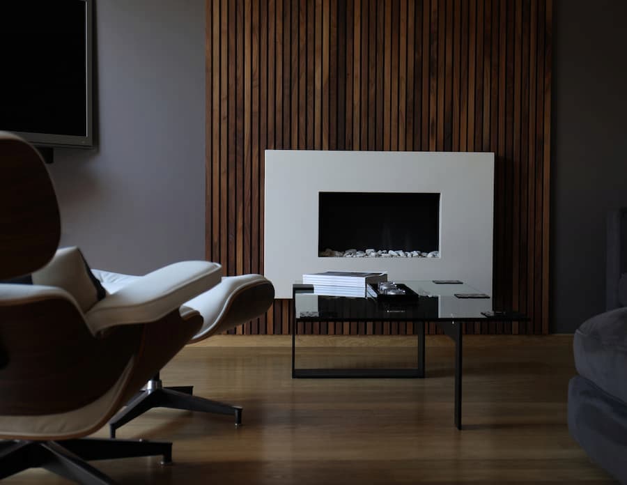 Modern living room with wood panelled feature wall using American black walnut set around a modern