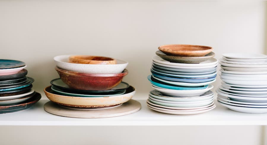 Selection of mismatched plates stacked in piles of varying sizes and colour