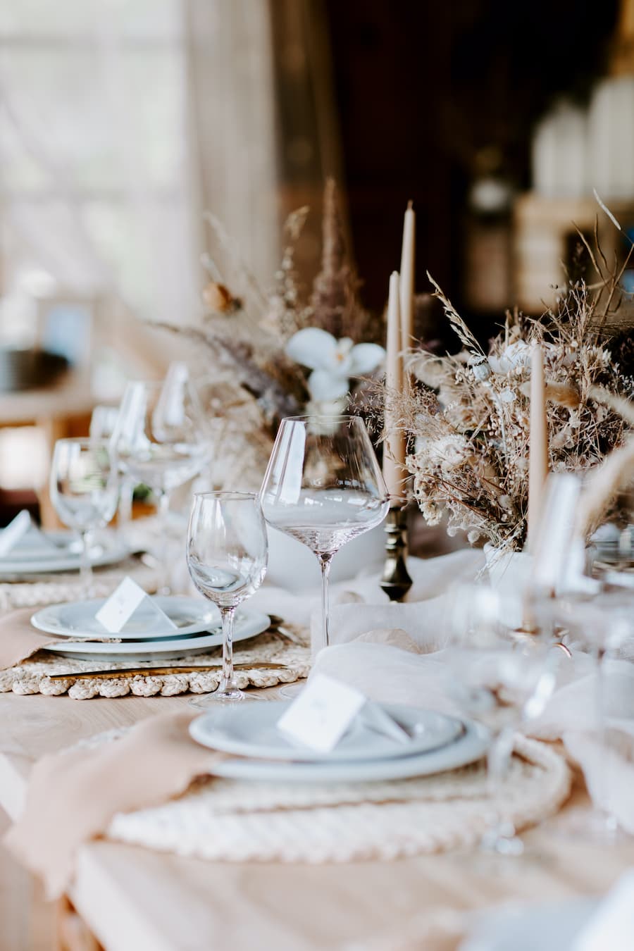 Beautiful tablescape setting with white china, glasses and neutral decorations