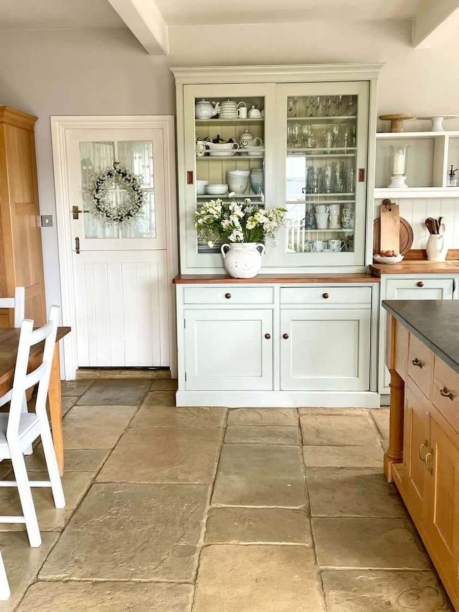Gorgeous farmhouse style kitchen with large flagstone tiles on the floor and a welsh dresser against the main kitchen wall