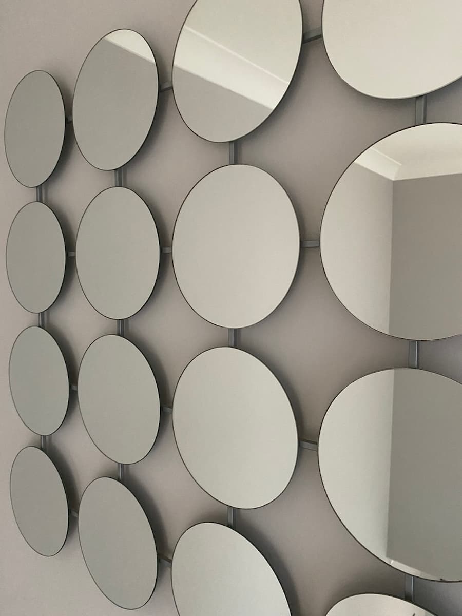 Modern mirror made up of 16 small circle mirrors, lined up 4x4
