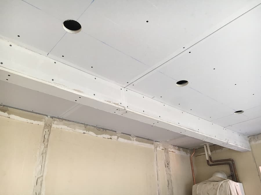 Kitchen ceiling re-boarded with holes cut out for spotlights