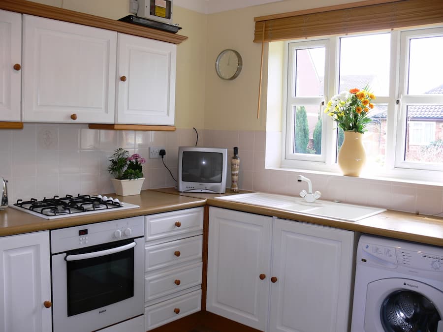 Original kitchen design Outdated white and oak kitchen with gas hob and oven underneath
