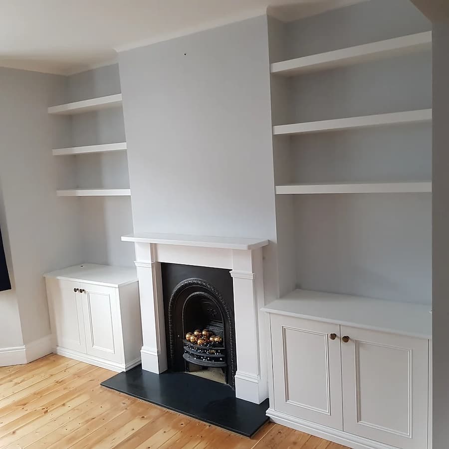Living room alcoves with built in shelves to the top and cupboards underneath