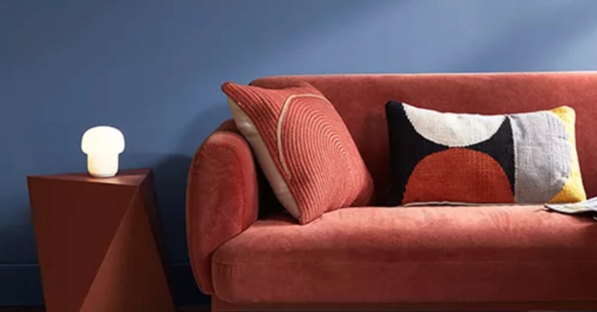 Benjamin Moore colour of the year Blue Nova painted walls with rustic orange sofa