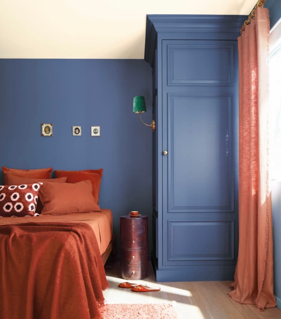 Benjamin Moore colour of the year Blue Nova painted walls with rustic orange bed