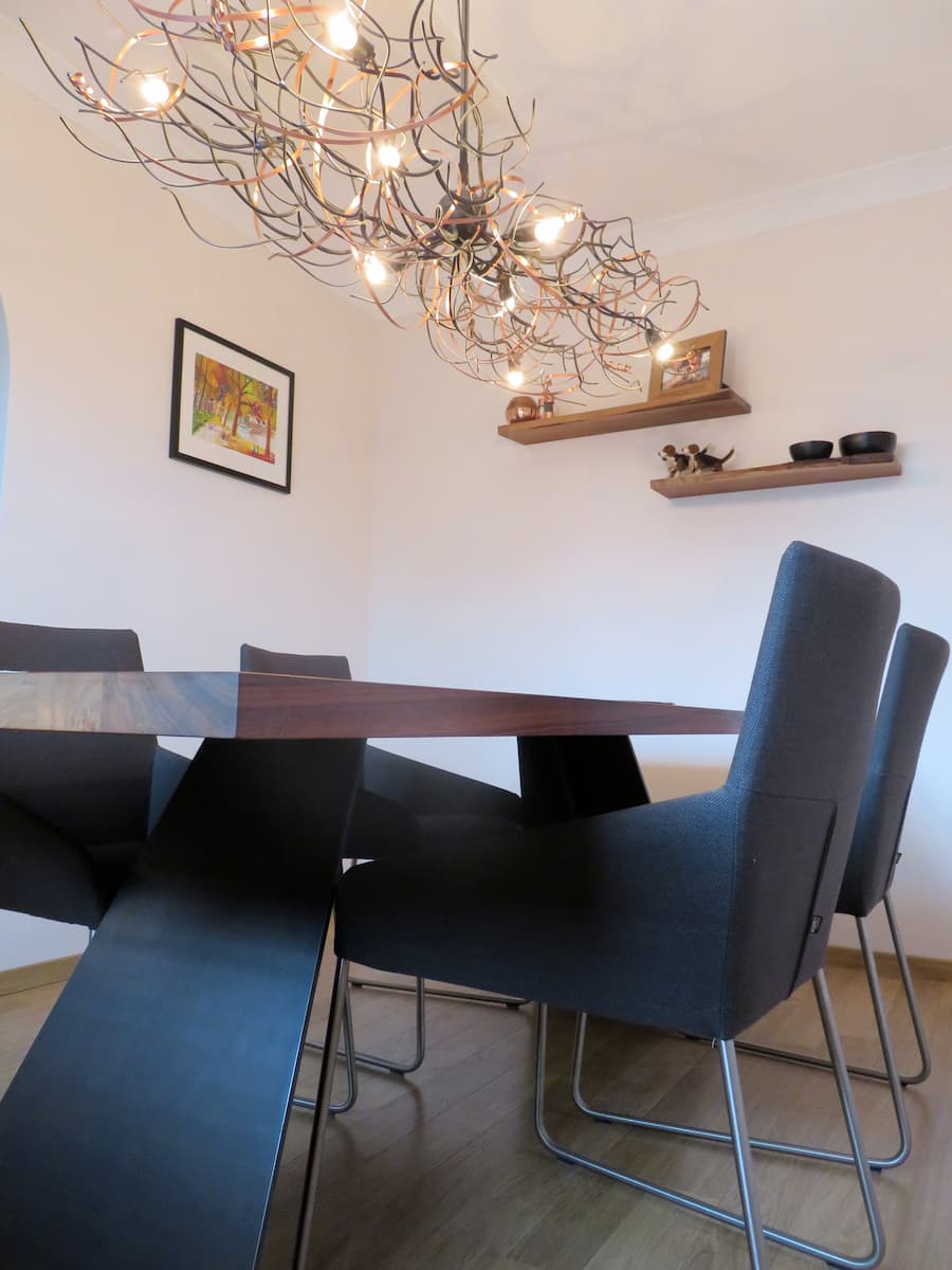 Feature light pendant position above a modern walnut dining table